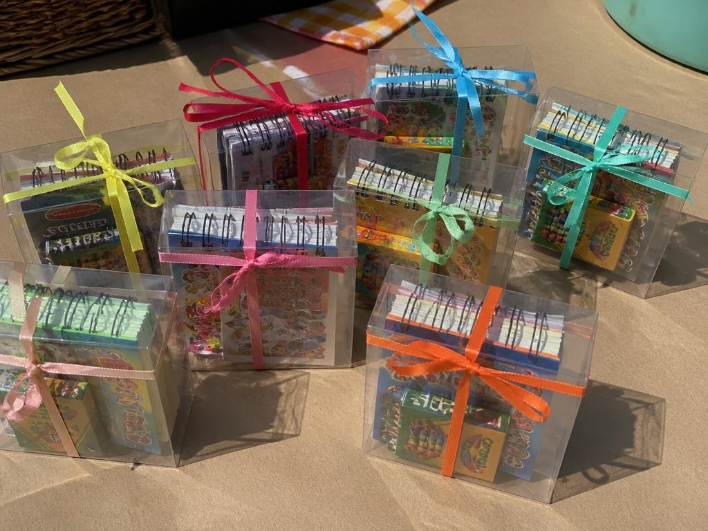 Crayons, a mini sketchbook and stickers, tied with a ribbon.