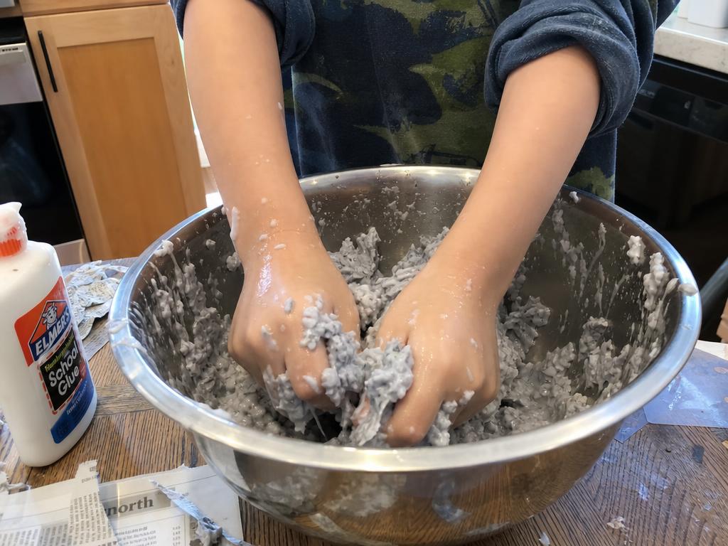 Shredded paper, warm water, a squeeze of soap and glue, mixed by hand until it behaves like clay.