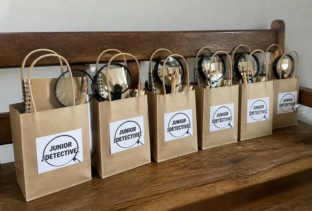 Favour boxes: magnifier, notebook, invisible ink and a badge.